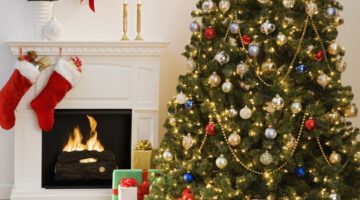 Christmas tree with presents and fireplace with stockings --- Image by © Royalty-Free/Corbis